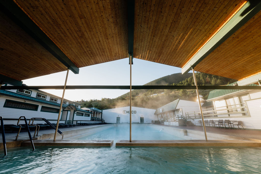 Chico Hot Springs' steaming outdoor pool under a timber canopy, mountains beyond