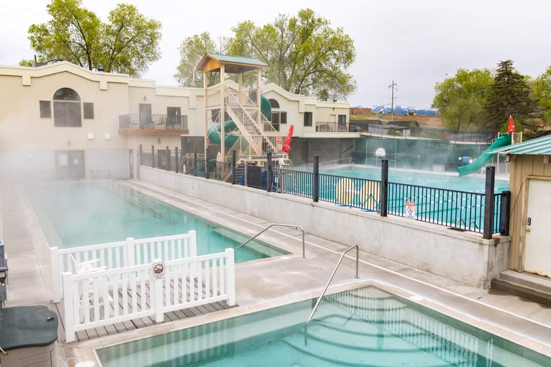 Steaming outdoor pools at Downata Hot Springs with slide tower behind