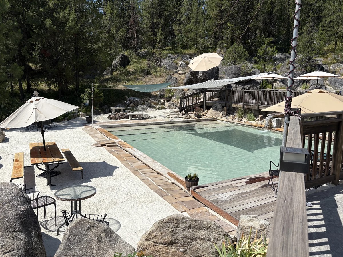 Gold Fork Hot Springs' terraced pools with umbrellas and boulders among pines