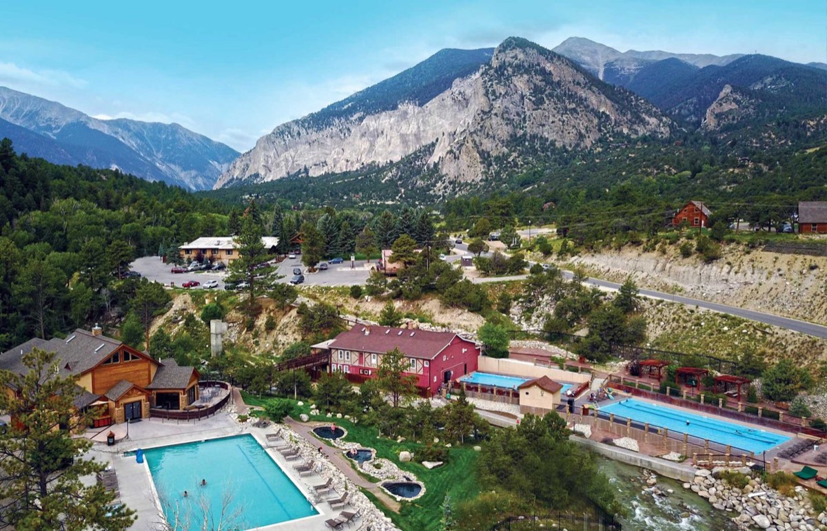 Aerial view of the resort's pools and creekside soaking area below the Chalk Cliffs in summer